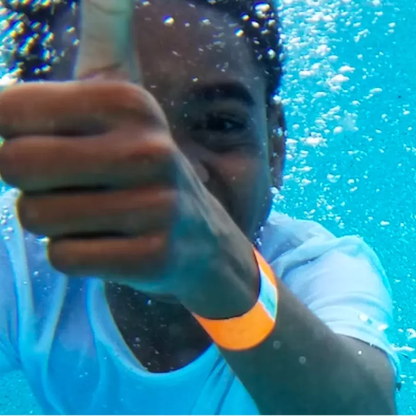 Boy thumbs up swimming