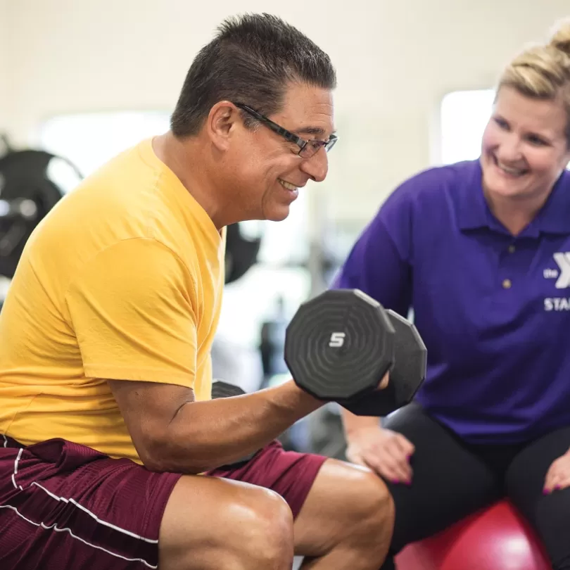 Personal exercise coach helping a gym member