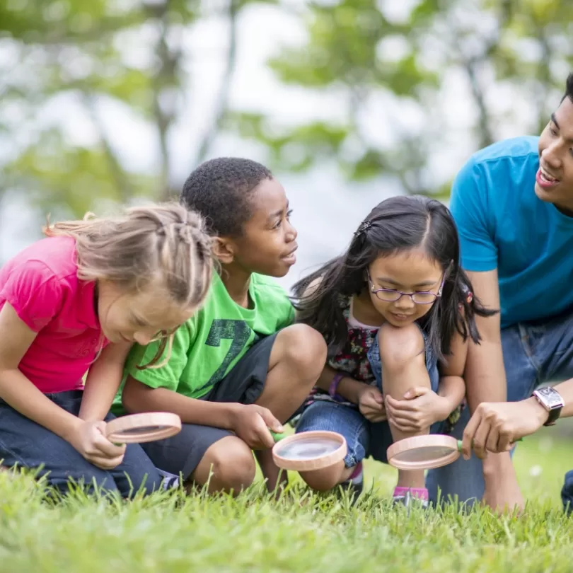 A summer day camp counselor with children