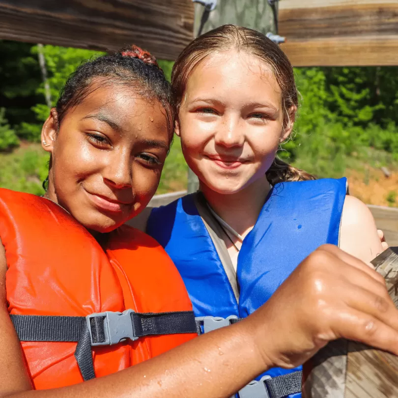 Two girls wearing life jackets at Camp Watia.