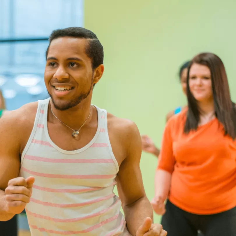 A man dances along with his dance group exercise class.