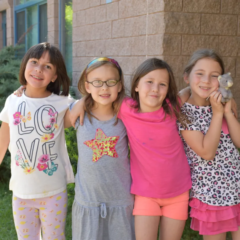 A group of girls smile at the camera during afterschool.