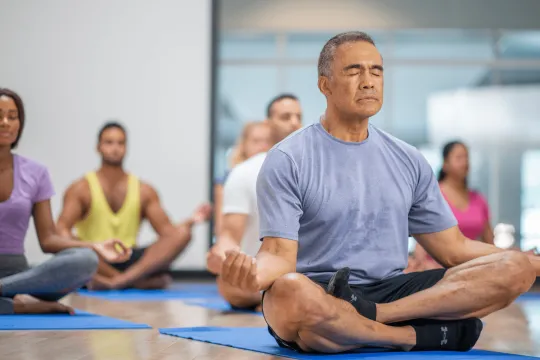 Elderly man in group yoga class.