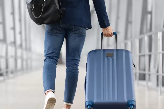 A picture of a person pulling their luggage through the airport.