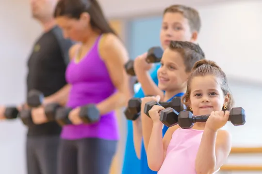 A family exercises together at the gym.