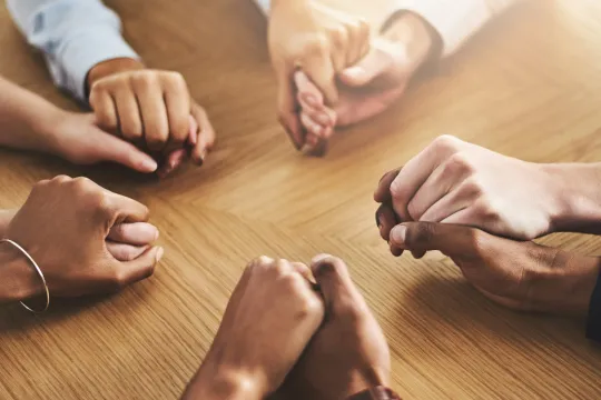 A group of people hold hands.