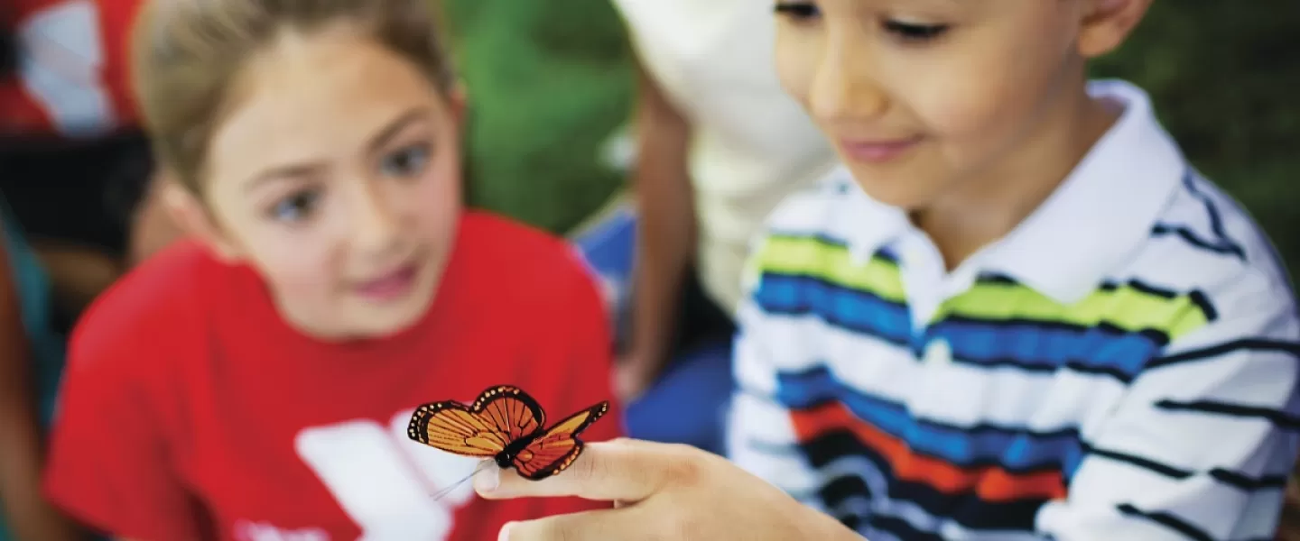 YMCA camper playing with butterfly