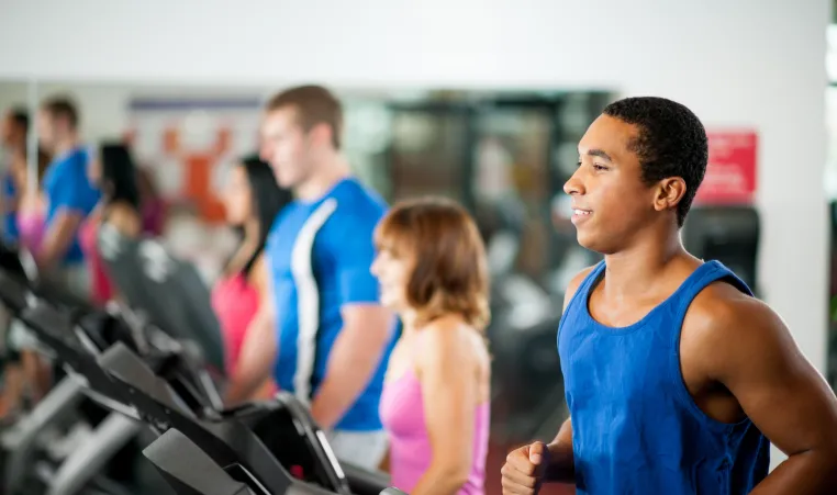 A man exercising on treadmill in a gym.