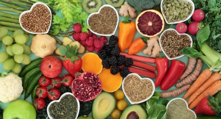 An above angle of a variety of healthy foods like fruits, vegetables, and nuts.