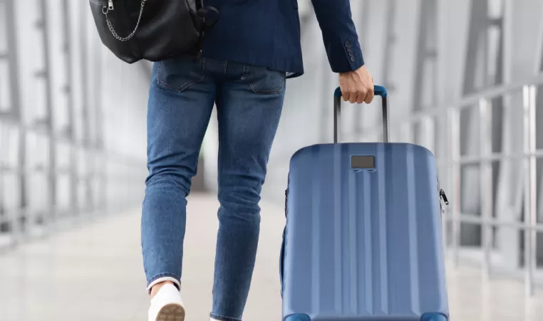 A picture of a person pulling their luggage through the airport.